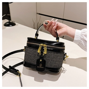 Detail of black woven mini bucket bag with gold hardware and BLONMAY brand tag
