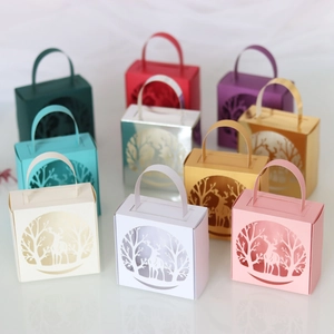 Detail of colorful laser-cut Christmas candy boxes featuring deer and tree hollow patterns