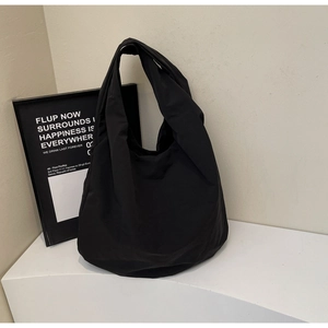 Dettaglio della borsa tote in nylon nero con trama a pieghe leggera e grande capacità interna