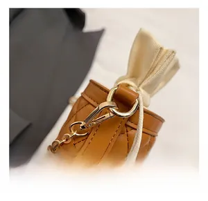 Detail of premium gold chain strap and metal hook on brown quilted leather bucket bag