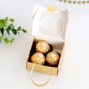 Detail of laser-cut cross gift box showing white lid with hollow design and gold base