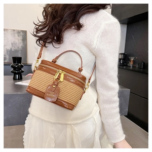 Detail of woven straw crossbody bag with leather trim and gold hardware by Bloomway