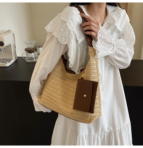 Detail of straw woven tote with leather straps and mini pouch in a cozy cafe setting