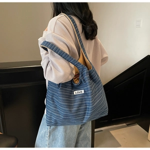 Detail of blue striped canvas tote bag with LOVE patch and spacious interior lining
