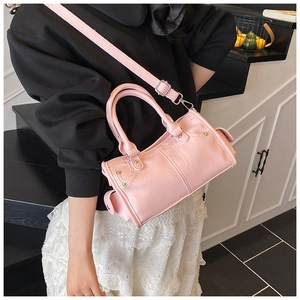 Borsa rosa in pelle a grana con manici intrecciati e dettagli di borchie metalliche
