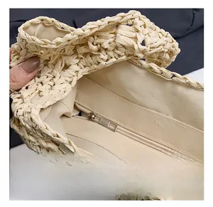 Detail view of woven straw tote bag featuring smooth metal zipper and durable canvas lining