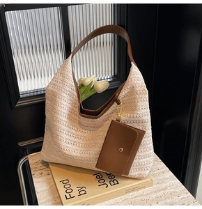 Detail of hand-woven off-white tote bag with brown leather straps and matching pouch