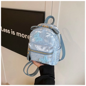 Detail view of light blue backpack featuring intricate jacquard and butterfly embroidery
