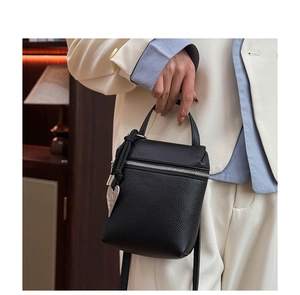 Detail of black lychee grain leather mini bag with silver heart charm and metal zipper