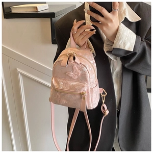 Detail of pink mini backpack featuring 3D butterfly embroidery and gold-tone zippers