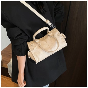 Elegante borsa a tracolla beige in pelle martellata con finiture argentate su modella