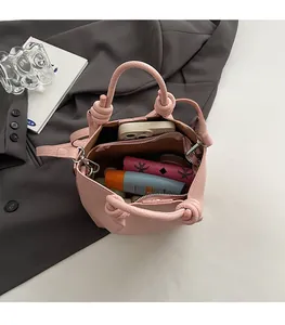 Pink lychee grain leather bucket bag showing spacious interior with phone and cosmetics