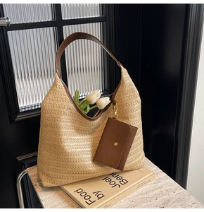 Detail of hand-woven straw tote bag with brown leather handle and matching mini pouch