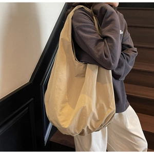 Dettaglio di una grande borsa tote beige in nylon morbido con design a pieghe stile nuvola