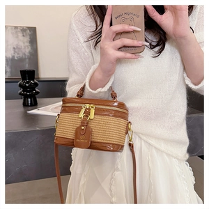 Brown woven bucket bag with leather trim worn by model in an elegant interior setting