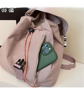 Detail of pink nylon backpack front zipper pocket storing a smartphone for daily use