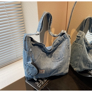 Detail view of large denim tote bag with front pockets and detachable round coin purse