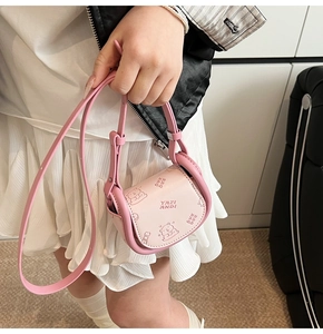 Detail of pink mini crossbody bag featuring a cute 3D bear emboss and sleek leather texture