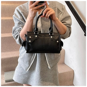 Dettaglio della borsa Boston in pelle martellata nera con rivetti argentati e metallo