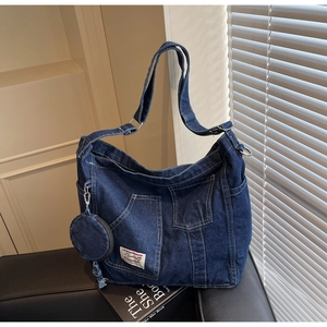 Detail of retro washed denim crossbody bag with dual pockets and round coin purse attachment