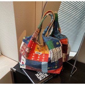 Detailed shot of a patchwork canvas tote bag with various colorful ethnic patterns and LOVE tag