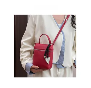 Detail of red lychee pattern leather mini bag with silver heart charm on white blazer