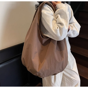 Dettaglio borsa tote marrone in nylon con texture a pieghe e ampia capacità interna