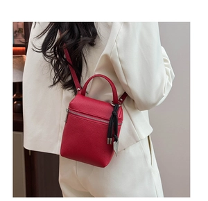Détail du mini sac en cuir rouge à motif litchi avec bandoulière et nœud décoratif