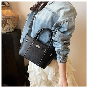 Borsa a secchiello in pelle nera con chiusura argentata indossata da una modella
