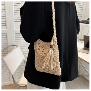 Détail du sac à bandoulière tissé ajouré avec glands bohèmes et perles en bois décoratives