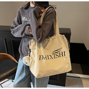 Detail of beige canvas tote bag with drawstring closure and small detachable round coin purse
