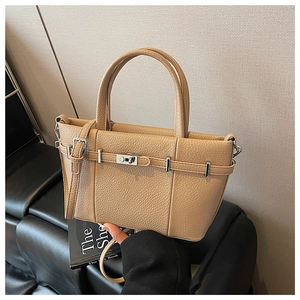 Dettaglio borsa a secchiello in pelle beige con chiusura girevole argento su panca