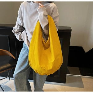 Grande borsa hobo in nylon giallo indossata da una modella in un contesto casual