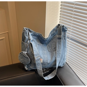 Detail of light blue denim tote bag with functional pockets and detachable round coin purse