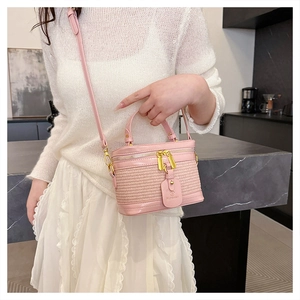 Detail of pink woven leather box bag showing gold zippers and brand hangtag