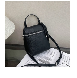 Vue détaillée du mini sac bandoulière en cuir grainé noir avec zip argenté et pompons