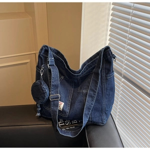 Detail of blue denim tote bag with contrast stitching and detachable round coin purse