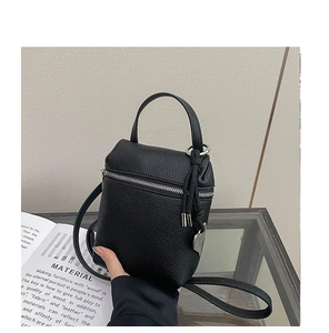 Detail of black lychee grain leather mini square bag with silver heart pendant
