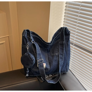 Detail view of denim tote bag showing vintage washed texture and adjustable strap buckle