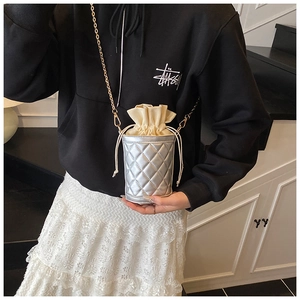 Detail of silver quilted bucket bag with chain strap and contrast drawstring lining