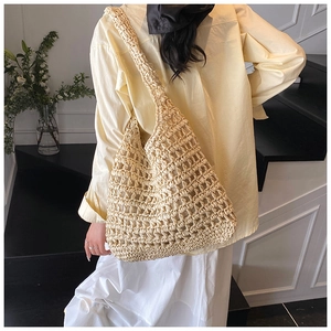 Hollow out straw shoulder bag showing the large capacity and lightweight woven texture