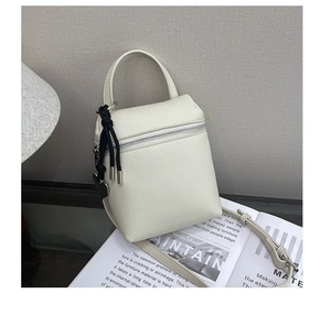 Détail du mini sac bandoulière en cuir grainé blanc crème avec fermeture éclair argentée