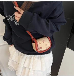 Close-up of mini saddle bag with red bear print and contrast stitching details