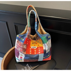 Detail of colorful patchwork tote bag showing LOVE label and metal magnetic closure
