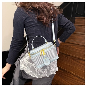 Detail of light blue box bag with woven texture, golden hardware and BLONMAY leather tag