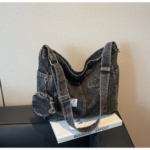 Detail of washed denim tote bag with side pocket and matching round coin purse charm