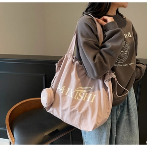 Detail shot of a light purple tote bag featuring a drawstring closure and mini coin purse