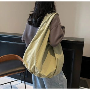 Vista posteriore di una grande borsa tote in nylon verde oliva con spallacci larghi
