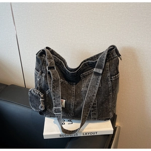 Detailed view of vintage washed denim tote bag with side pockets and mini pouch