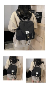 Detailed view of black nylon drawstring bucket backpack with metal buckle and woven label